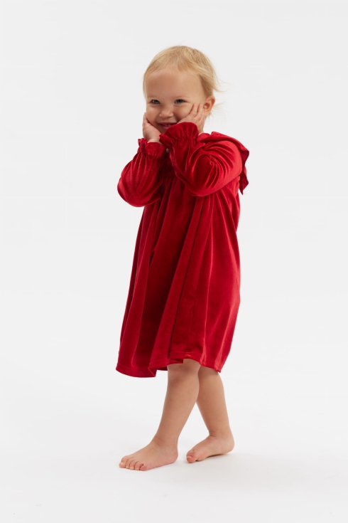 Menina a sorrir com vestido de veludo vermelho Idalia de manga comprida