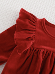 Pormenor do tecido em veludo vermelho macio do vestido de festa para menina