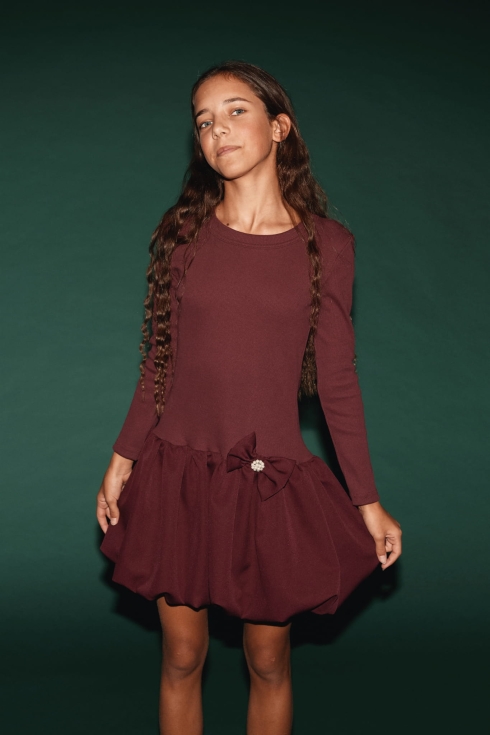 Menina a posar de frente com vestido Aria bordô de manga comprida