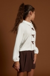 Camisa ecru com laços castanhos e saia calção castanha em look de cerimónia para menina