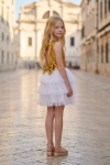 Vestido Riva branco e dourado ao ar livre – costas com decote em gota e laço de lantejoulas, saia de tule