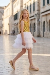Vestido Riva branco e dourado ao ar livre – corpo de lantejoulas e saia de tule em camadas, vista lateral