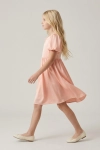 Vestido de cerimónia Sia cor-de-rosa – perfil com saia rodada em movimento