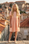 Vestido de cerimónia Sia cor-de-rosa – silhueta completa de frente, com a cidade antiga ao fundo