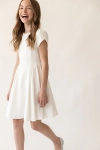 Vestido de cerimónia Rumi branco para menina, com mangas tulipa – menina sorridente em movimento, vista de frente