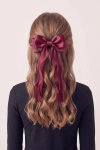 Mola de cabelo com laço bordô presa no cabelo, com fitas compridas – vista de trás