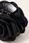 Pinça de cabelo preta com flor – grande plano da mola e da textura das pétalas de tecido
